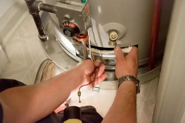 Technician working on the gas control valve of a water heater