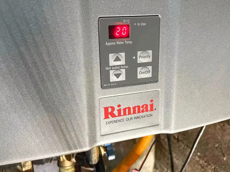 Rinnai tankless water heater control panel above new gas and water shutoff valves