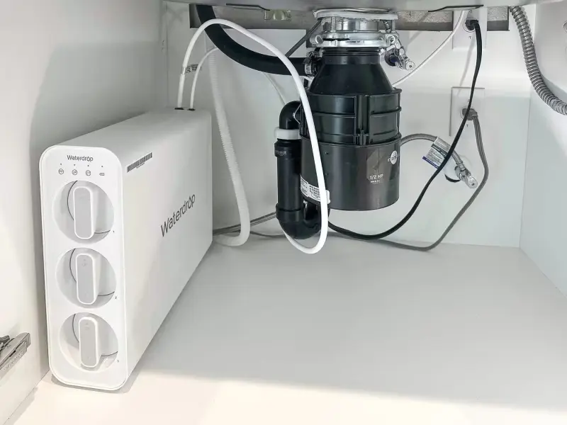 Waterdrop reverse osmosis filter system under a kitchen sink beside the garbage disposal