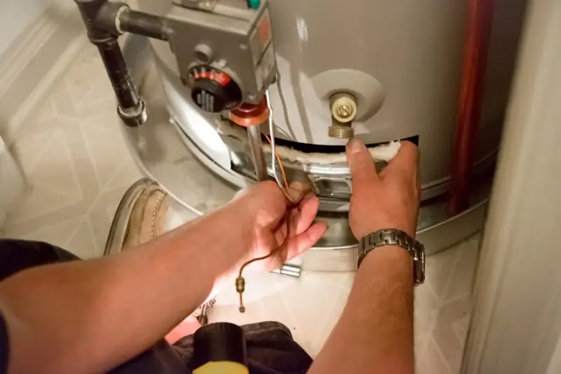 Technician repairing a home water heater — Beaver Brothers Plumbing